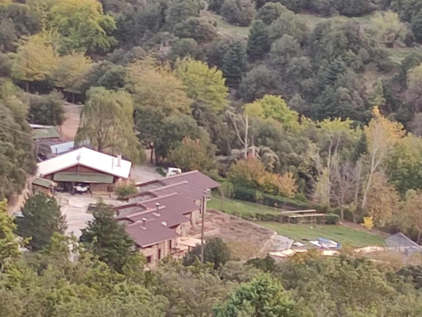 Το κτήμα από ψηλά, με τα πέτρινα κτίρια ανάμεσα σε δάσος
